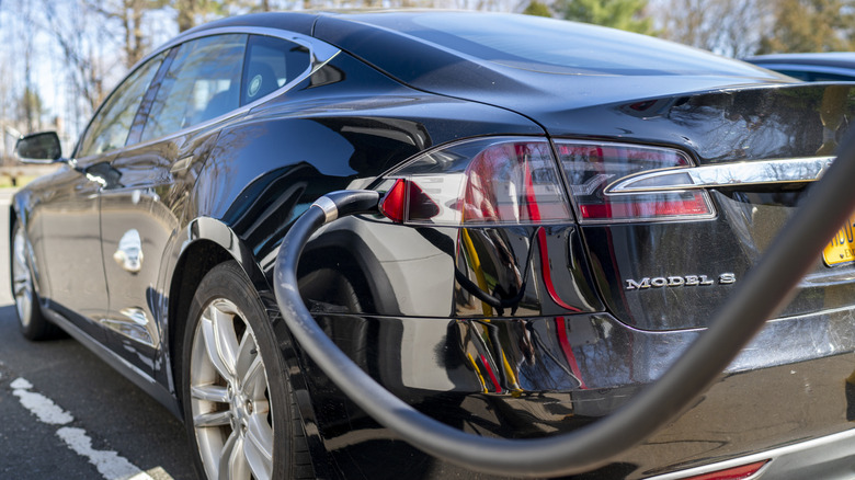 A black Tesla Model S at a charging station.