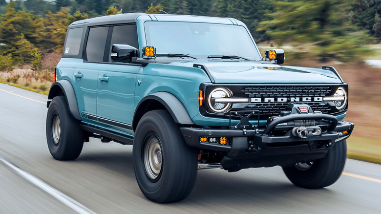 A blue Ford Bronco drives on the highway.