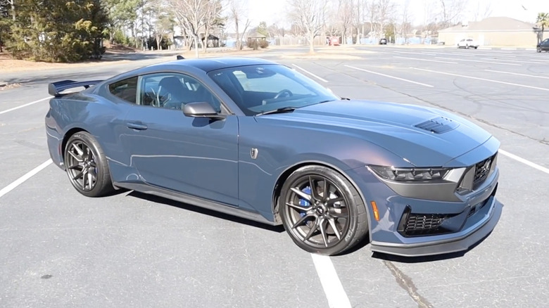 A gray 2024 Ford Mustang Dark Horse (10-speed automatic) parked on a sunny day in an asphalt parking lot.