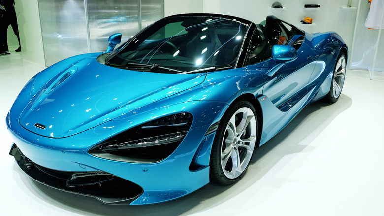A light blue 2019 McLaren Senna in a showroom setting on a white floor.