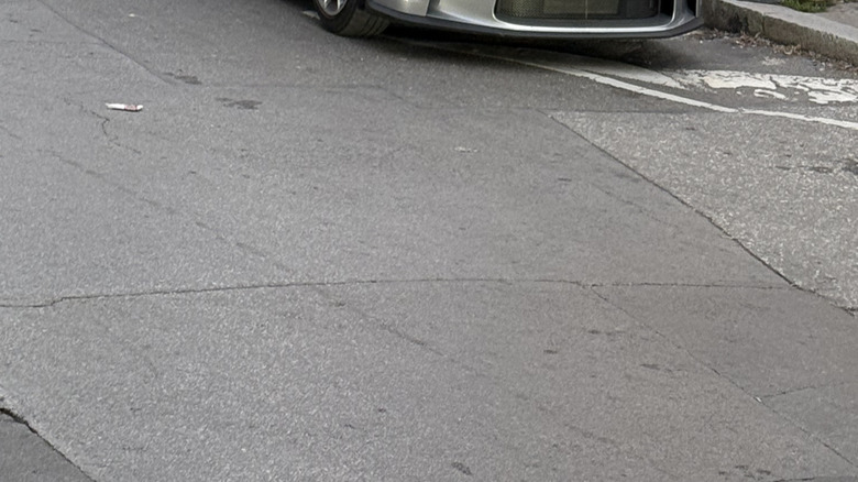 A silver 2025 Porsche 911 GT3 Touring parked on a city street.