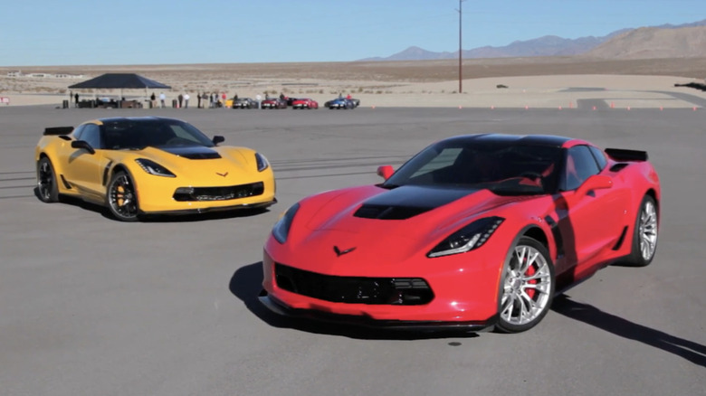 Two 2015 Chevrolet Corvette Z06, onme red and one yellow, parked on an asphalt lot with the desert and mountains in the background.