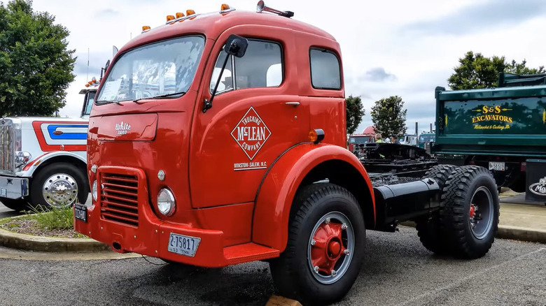 An Art Deco-styled, bright red White 3000 cab-over tractor chassis parked on a lot.