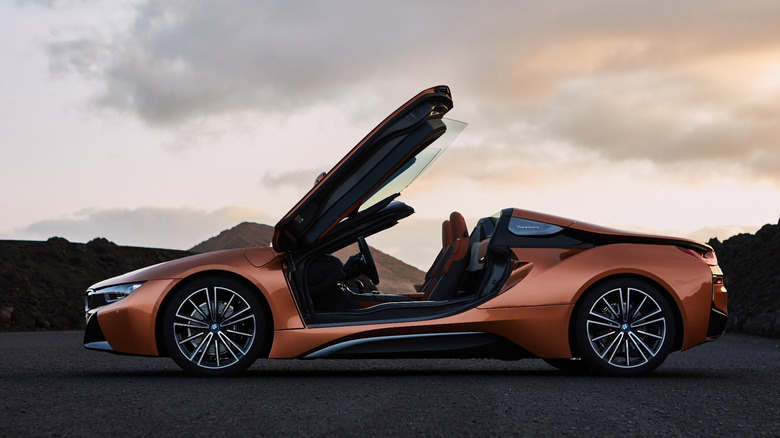 A side view of an orange BMW i8 Coupe with its doors open