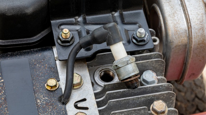 Spark plug removed from lawnmower engine