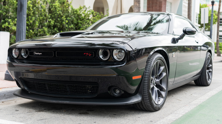 A black Dodge Challenger parked outside.