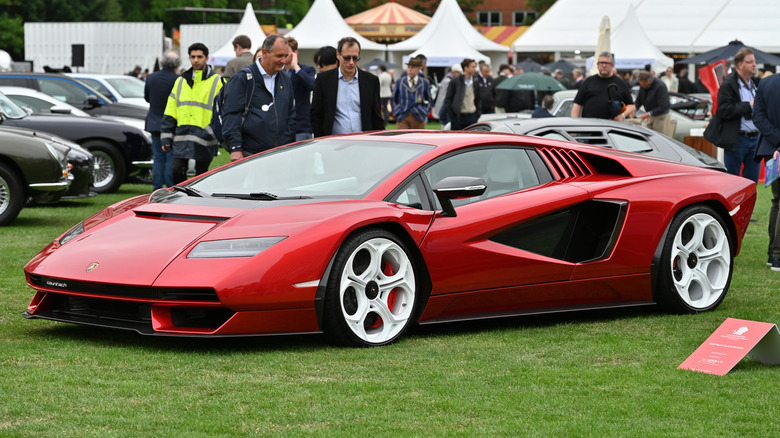 A red Lamborghini Countach LPI 800 parked on display on a lawn.