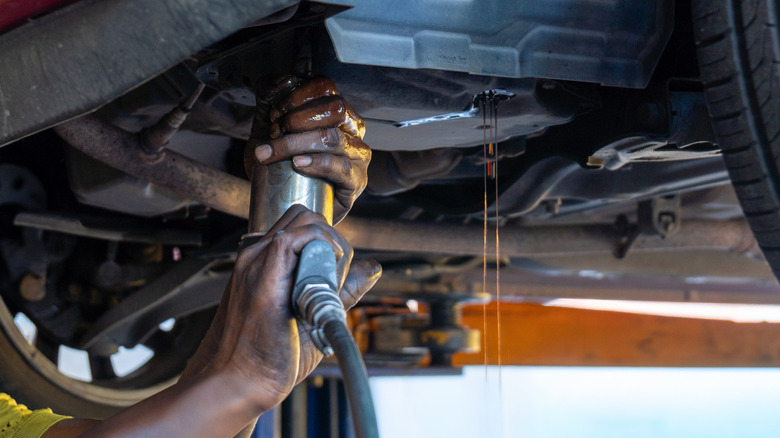 Mechanic removing the ATF pan cover and draining out the old fluid
