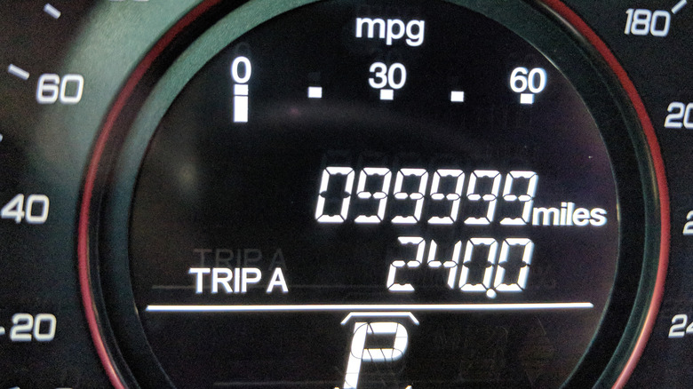 A digital odometer of a car showing 99,999 miles