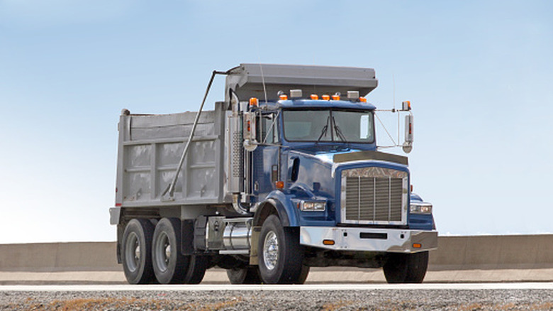 A blue dump truck sits parked.