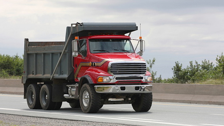 Red dump truck on the highway.