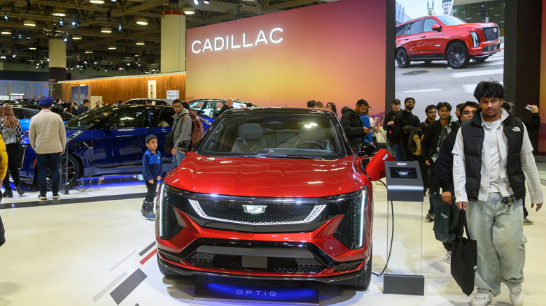 A red Cadillac Optiq displayed at a car show.