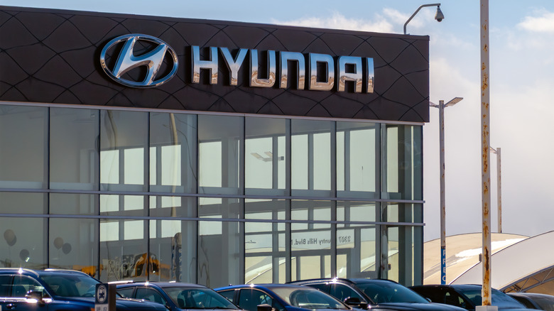Hyundai dealership exterior with vehicles parked in front of the building.