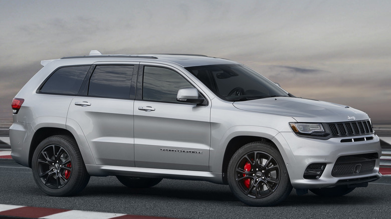 A Silver 2021 Jeep Grand Cherokee Trackhawk parked on a track.