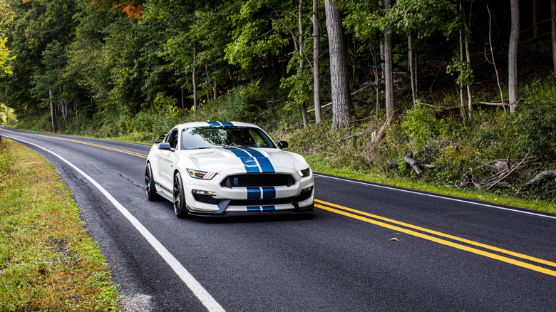 A white and blue 2020 Ford Mustang Shelby GT350R Heritage Edition driving on a scenic road