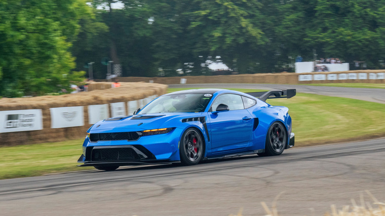 A blue Ford Mustang GTD going around a turn at the Goodwood Festival of Speed