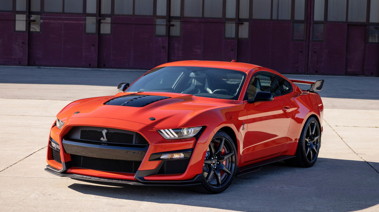 A red 2022 Ford Mustang Shelby GT500 parked in front of a building