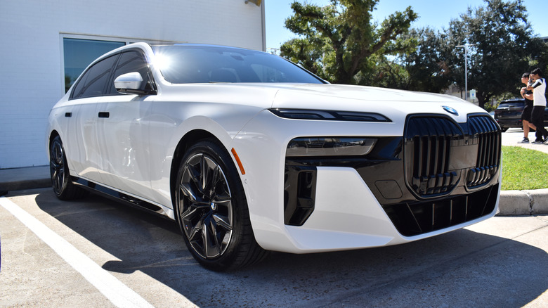 A white BMW i7 sits in a parking space.