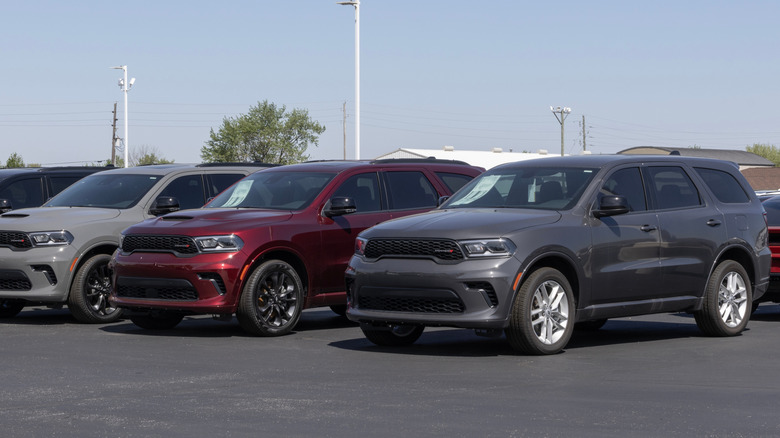 Several Dodge Durango vehicles wait in a parking lot.