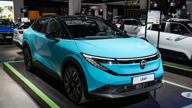 A blue Nissan Leaf is on display at an auto show.
