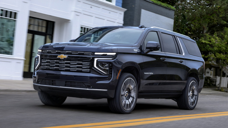 A 2026 Chevrolet Suburban drivng down a road