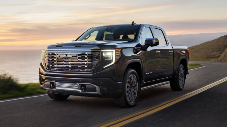 A black GMC Sierra driving down a mountainside road