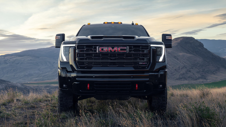 The grille of a 2026 GMC Sierra HD parked on grass, showing its logo
