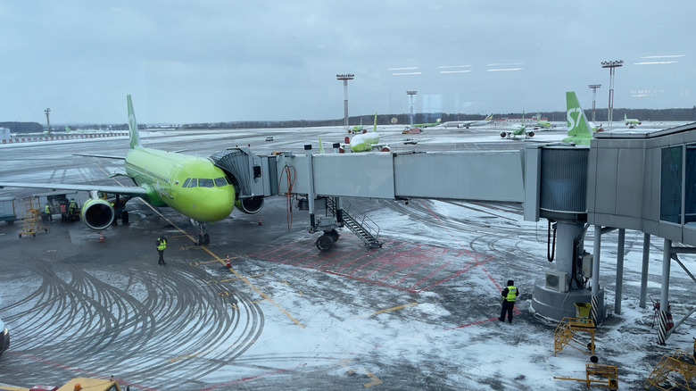 A airport terminal gangway stretching out to a parked aircraft