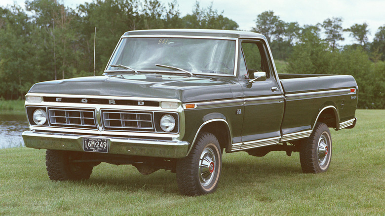 A green 1976 Ford F-150, then only a year old as a model, standing in a grassy field on a cloudy day.