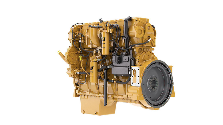 A 3/4 view of a yellow Caterpilla C15 15.2-liter turbocharged inline-6 engine on white background