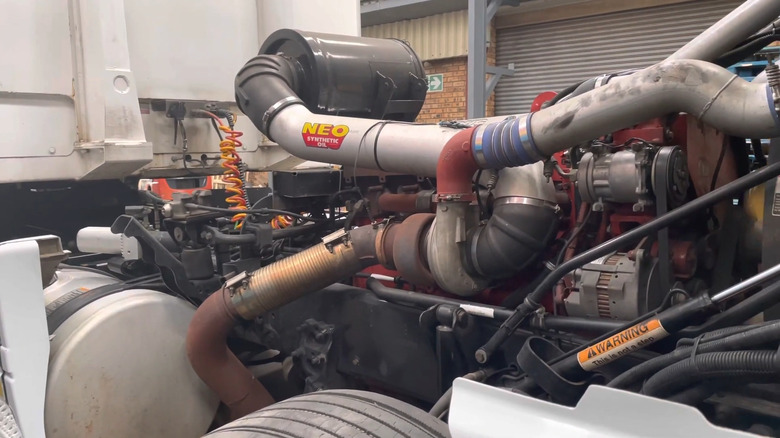 Cummins Signature 600 engine shown on a semi truck with a NEO synthetic oil sticker on the exhaust pipe