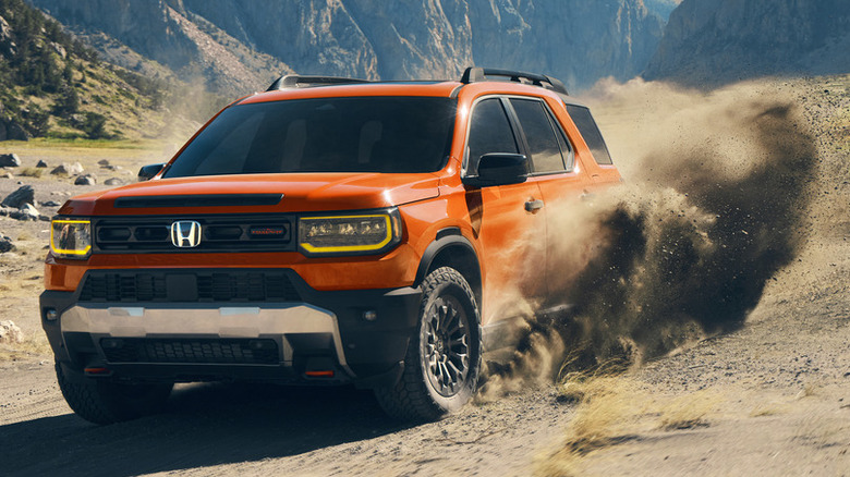 A bright orange 2026 Honda Passport TrailSport driving through a sandy trail, kicking up a heavy cloud of dirt and dust from its rear tire.