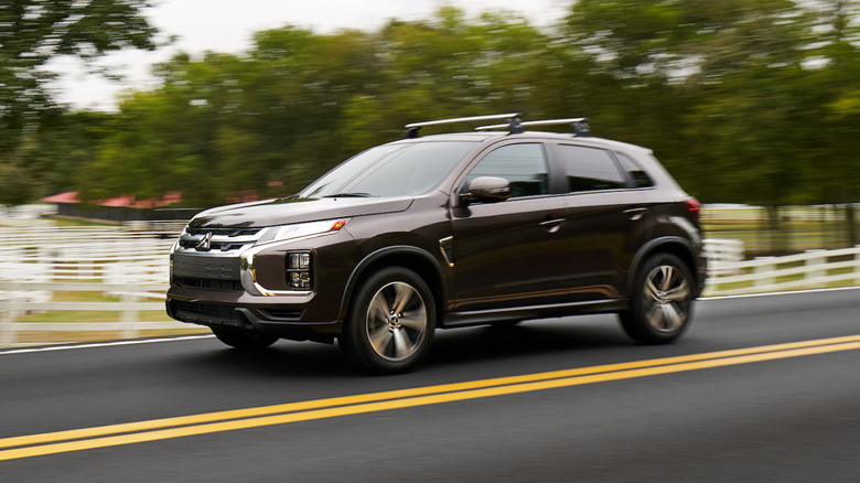 A front 3/4 of a Mitsubishi Outlander Sport on a country road with roof bars