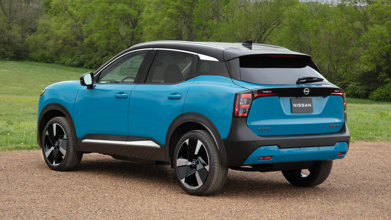 A rear 3/4 shot of a two-tone 2026 Nissan Kicks parked on dirt