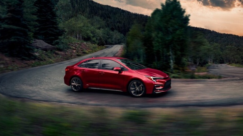 A 2026 Toyota Corolla Hybrid SE on a winding road in stormy weather