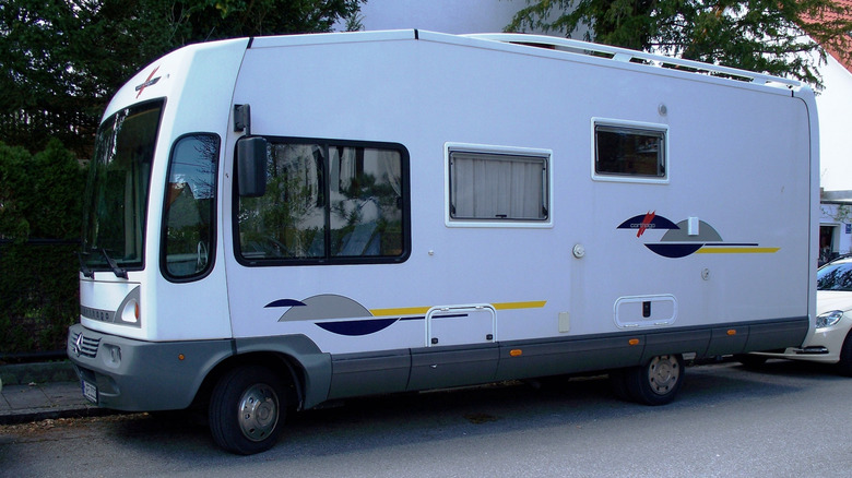 An RV parked by the sidewalk