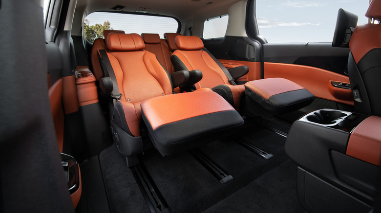 A look at the reclining lounge-like orange rear seats in the Kia Carnival complete with footrests