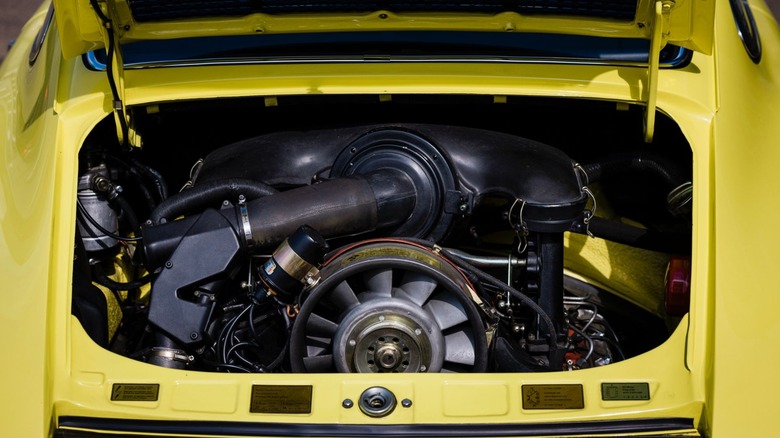 Looking down into the rear engine bay of a classic bright yellow Porsche 911 Carrera RS 2.7
