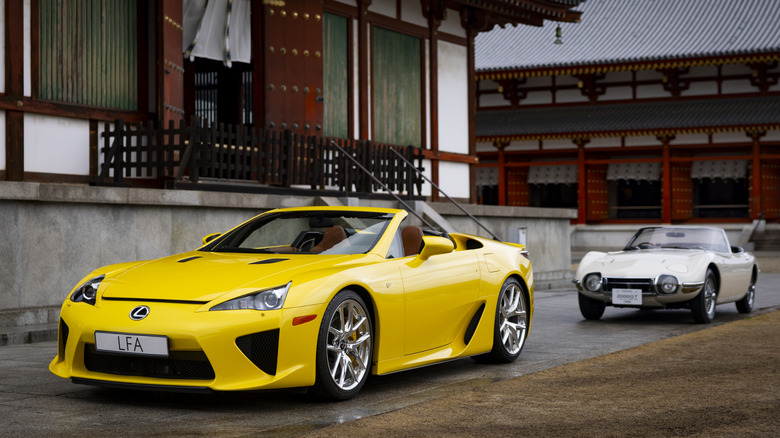 A yellow Lexus LFA Spider alongside a Toyota 2000GT Convertible
