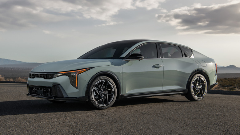 A grey 2026 Kia K4 under a cloudy sky