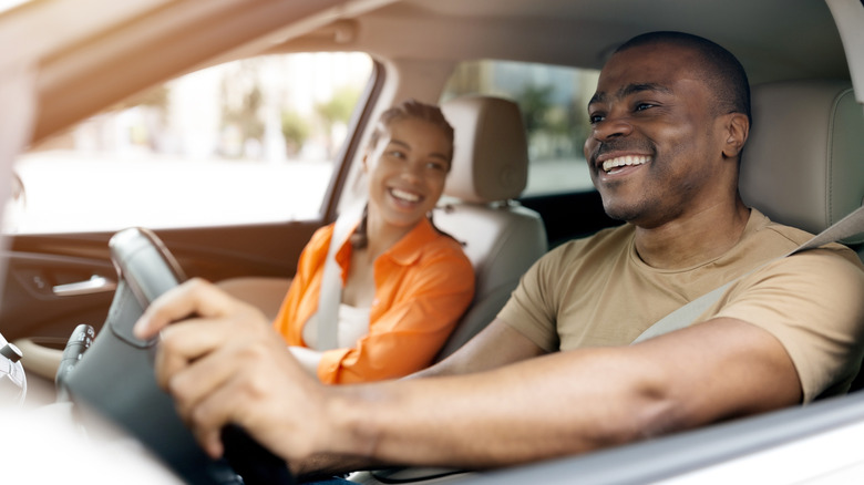 A young couple driving in a car