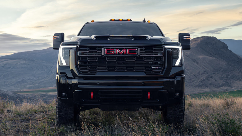 The front of a black 2026 GMC Sierra HD on grassy terrain