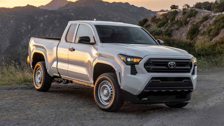 2025 Toyota Tacoma SR parked on a paved road surface with mountains in the background
