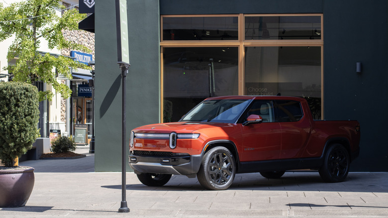 An orange 2025 Rivian R1T on display at Rivian's Oregon space.