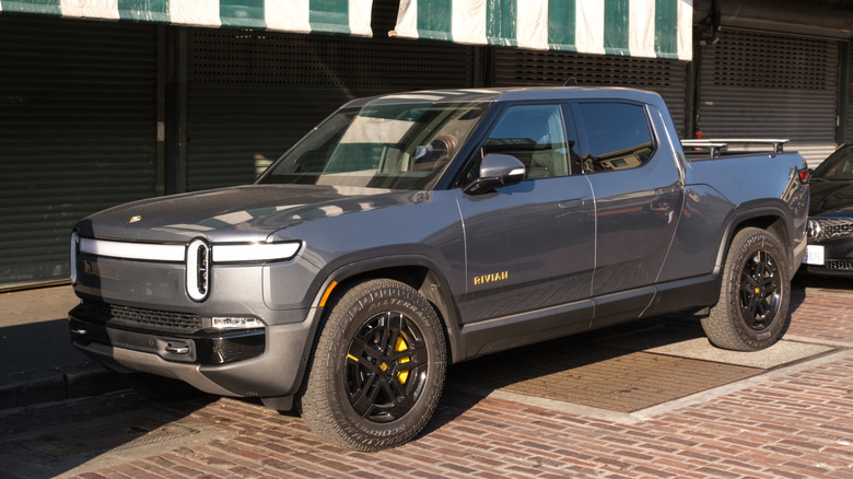 A 2023 Rivian R1T parked on a brick street in the sunlight.