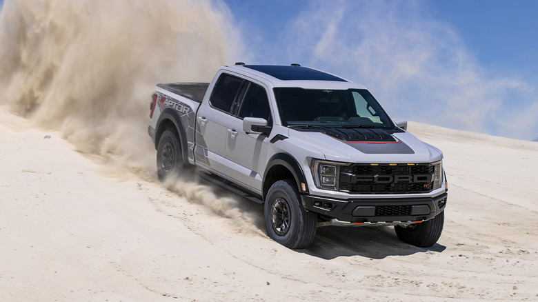 Grey 2023 Ford F-150 Raptor R rips through sand dunes on a sunny day.