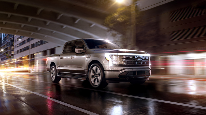 Product image of 2022 Ford F-150 Lightning Platinum driving through urban tunnel at night.