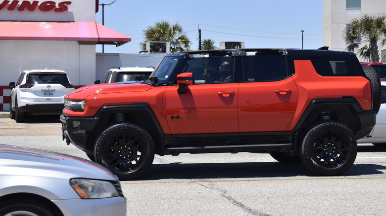 Side view of an orange Hummer EV