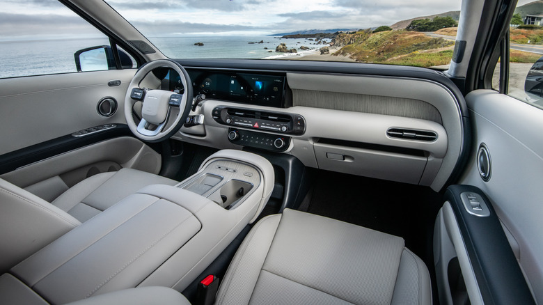 A photo of the dashboard and front seats in a new Hyundai Palisade Calligraphy parked in front of the ocean