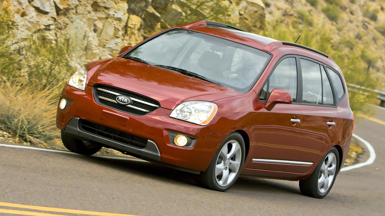 Kia Rondo being driven around a corner on a mountain road